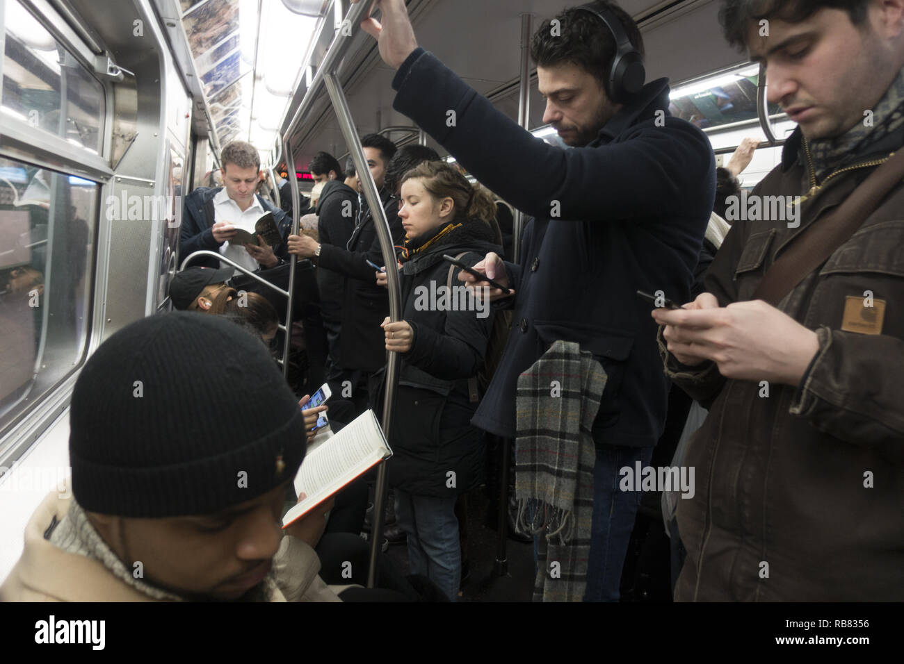 Subway train riders going from Brooklyn to Manhattan on an F train in
