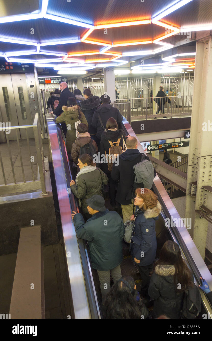 Subway train riders ride the escalator that connects the F train Broadway Lafayette Station with the Bleeker Street No. 6 train station  in Manhattan. Stock Photo
