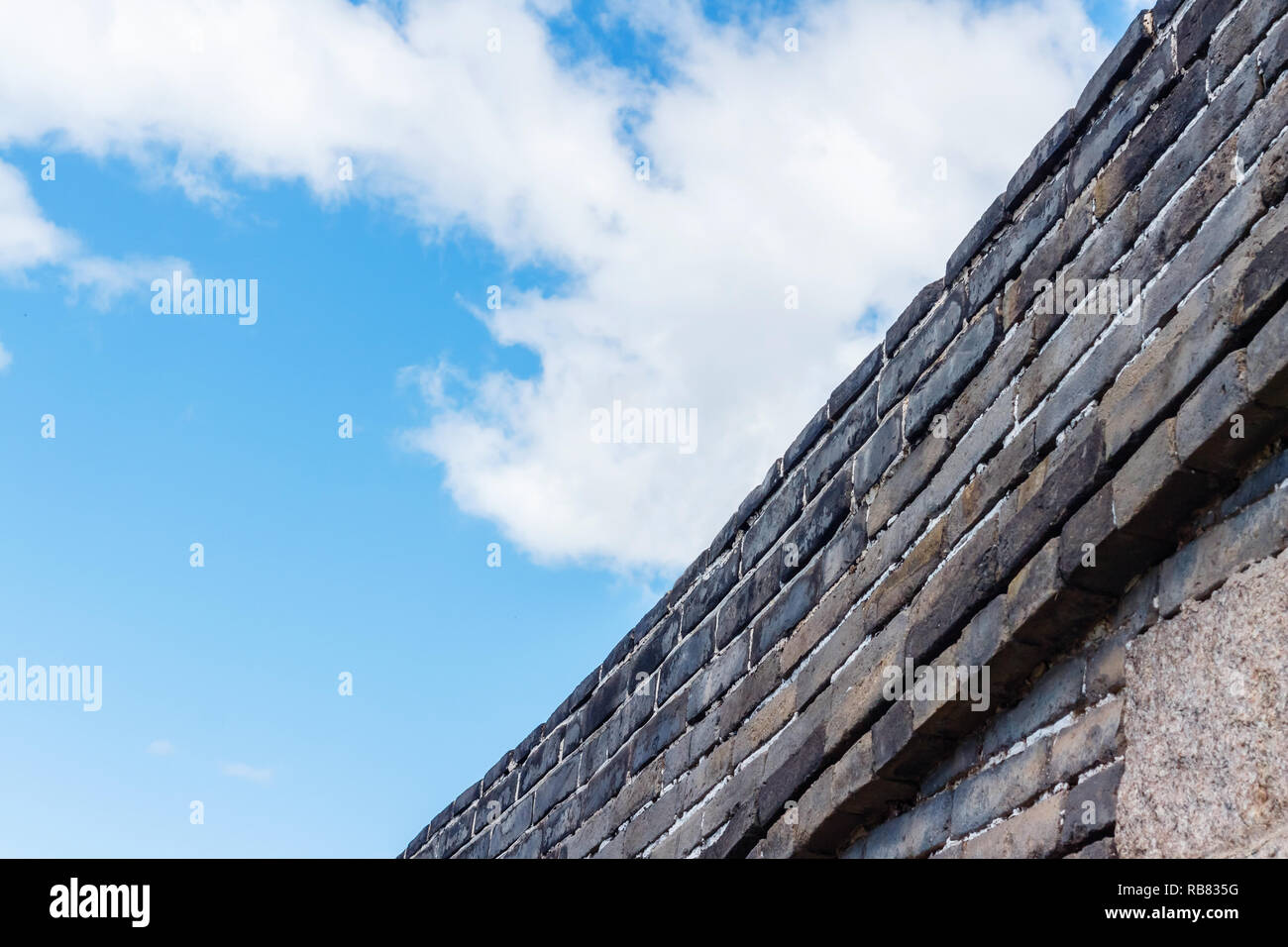 Sky clouds over stone fence Stock Photo
