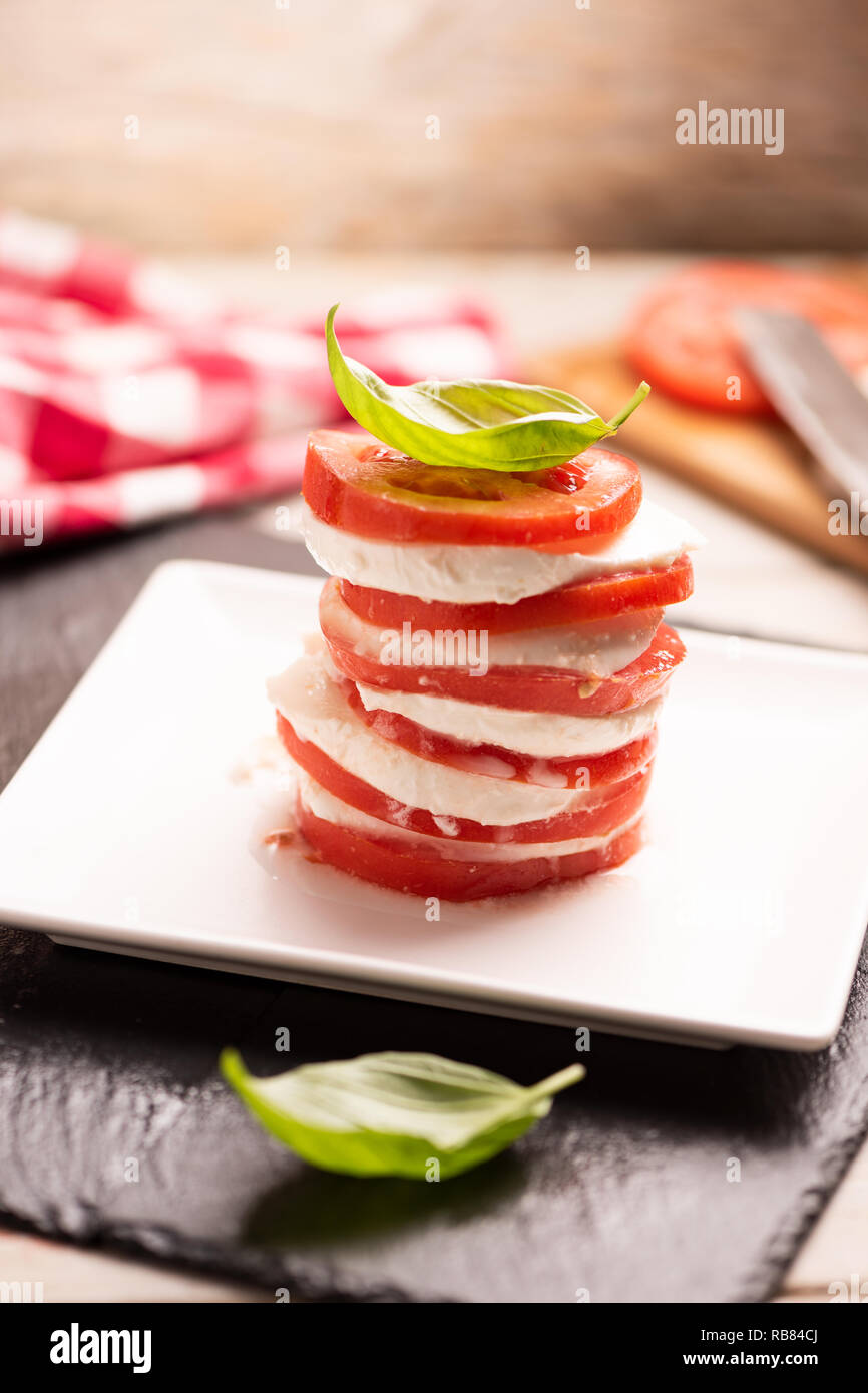 Tomato and Mozzarella slices with basil leaves Stock Photo - Alamy