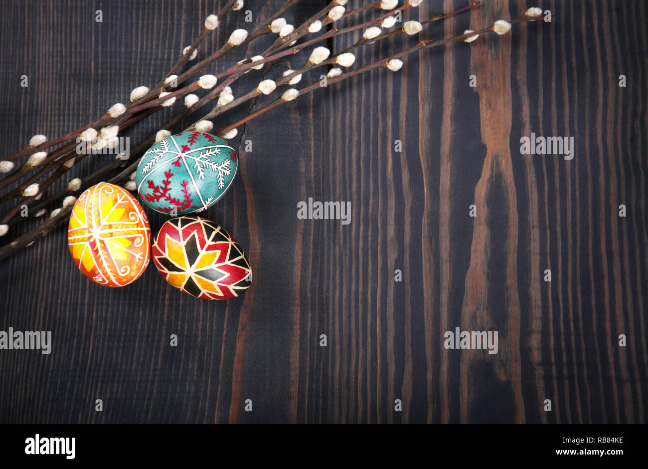 Easter eggs with willow twigs on a wooden plank table. The concept of ...