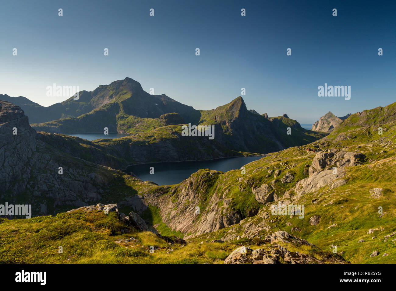 View of the mountains, lakes and fjords near Sørvågen on Moskenesøya, the Lofoten islands in Norway, Europe. Also shows Hermannsdalstinden mountain. Stock Photo
