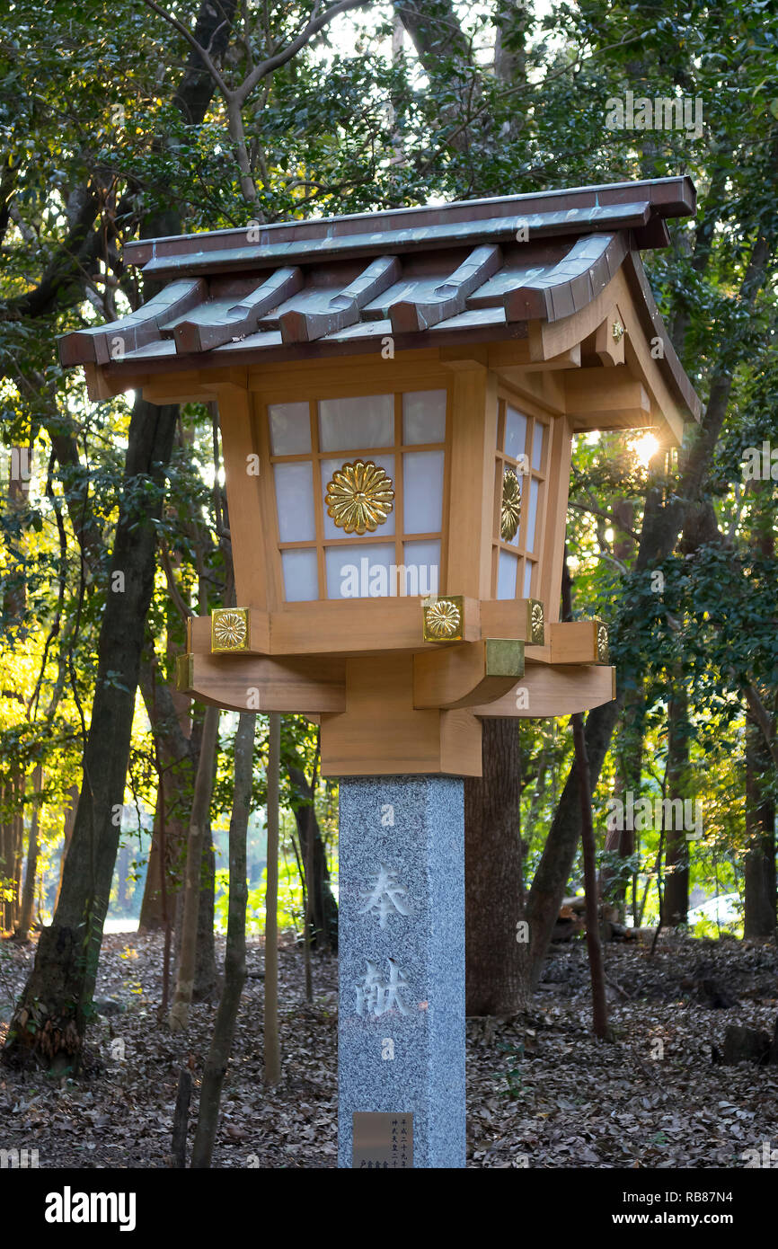 Miyazaki, Japan - November 4, 2018: New and modern stone lantern decorated with a golden chrysanthemum at the Miyazaki Jingu shrine grounds Stock Photo