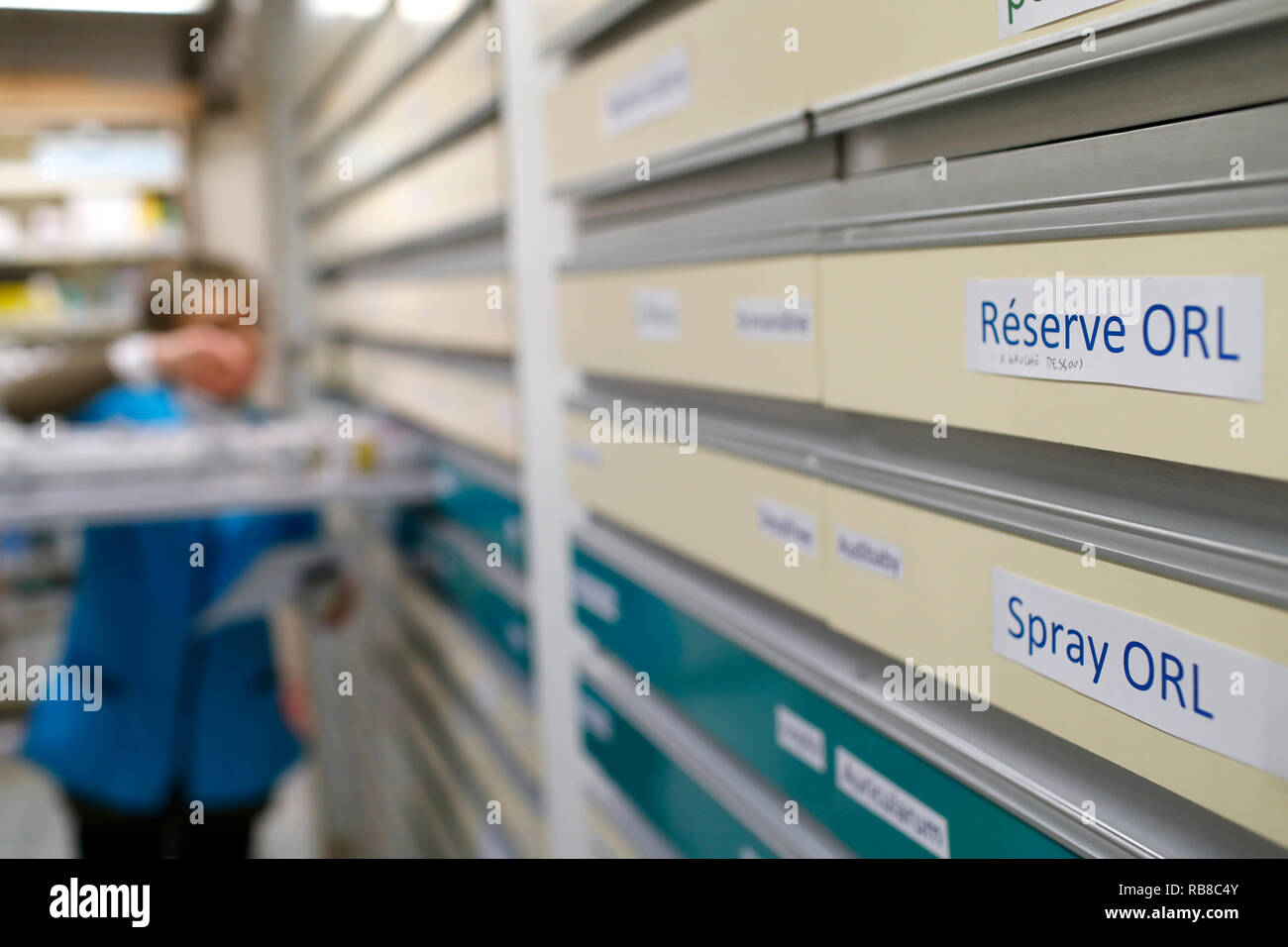 Pharmacy. Pharmacist taking drug from a drawer cabinet. France. Stock Photo