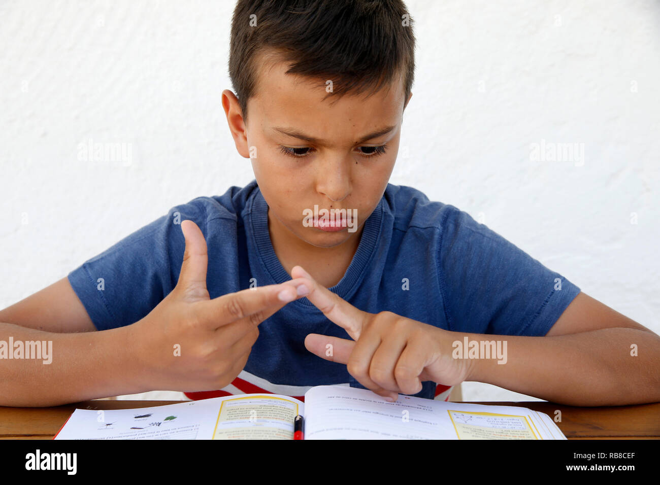 11-year-old boy doing homework in Salento, Italy. Stock Photo
