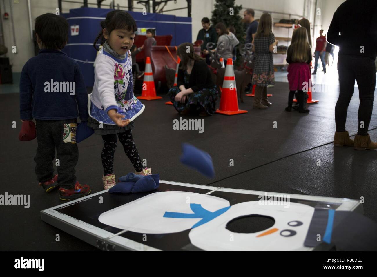 Cocona, a child from ARFF Tsuta Orphanage, plays corn hole during the ARFF Tsuta Christmas party at Marine Corps Air Station Iwakuni, Japan, Dec. 10, 2016. ARFF holds the event annually to help spread Christmas cheer to the orphans and to bring service members, their families and the Japanese together. Activities such as a bouncy house, Christmas cookie decorating and games were available to the children during the event. Stock Photo