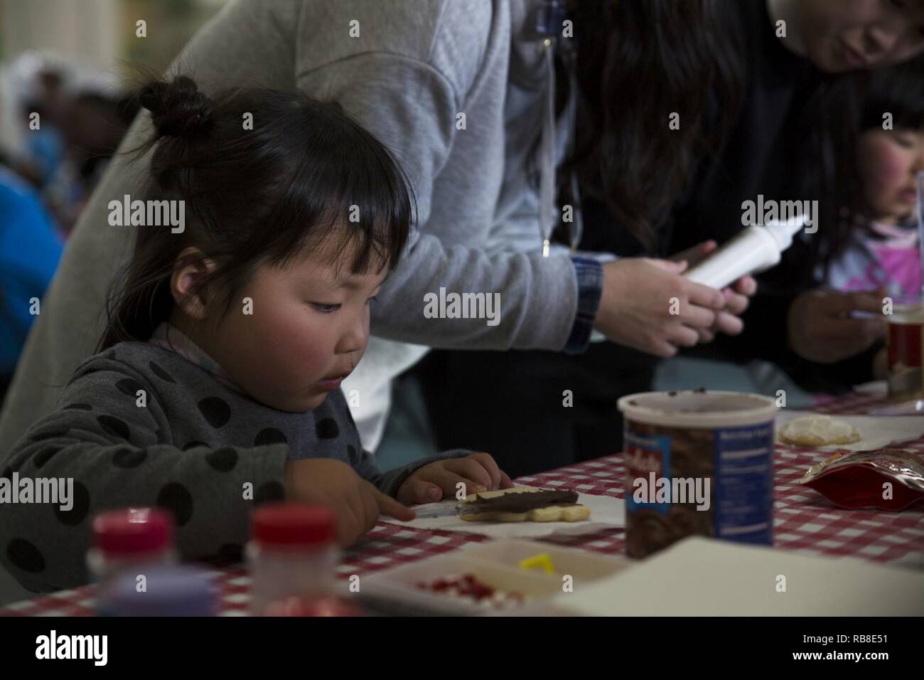 May Yamane, a child from the local orphanage, decorates Christmas cookies at the ARFF Tsuta Orphanage Christmas party at Marine Corps Air Station Iwakuni, Japan, Dec. 10, 2016. ARFF holds the celebration annually to help spread holiday cheer to the orphans and to bring service members, their families and Japanese together. Activities such as a bouncy house, Christmas cookie decorating, and games were available to the children during the party. Stock Photo