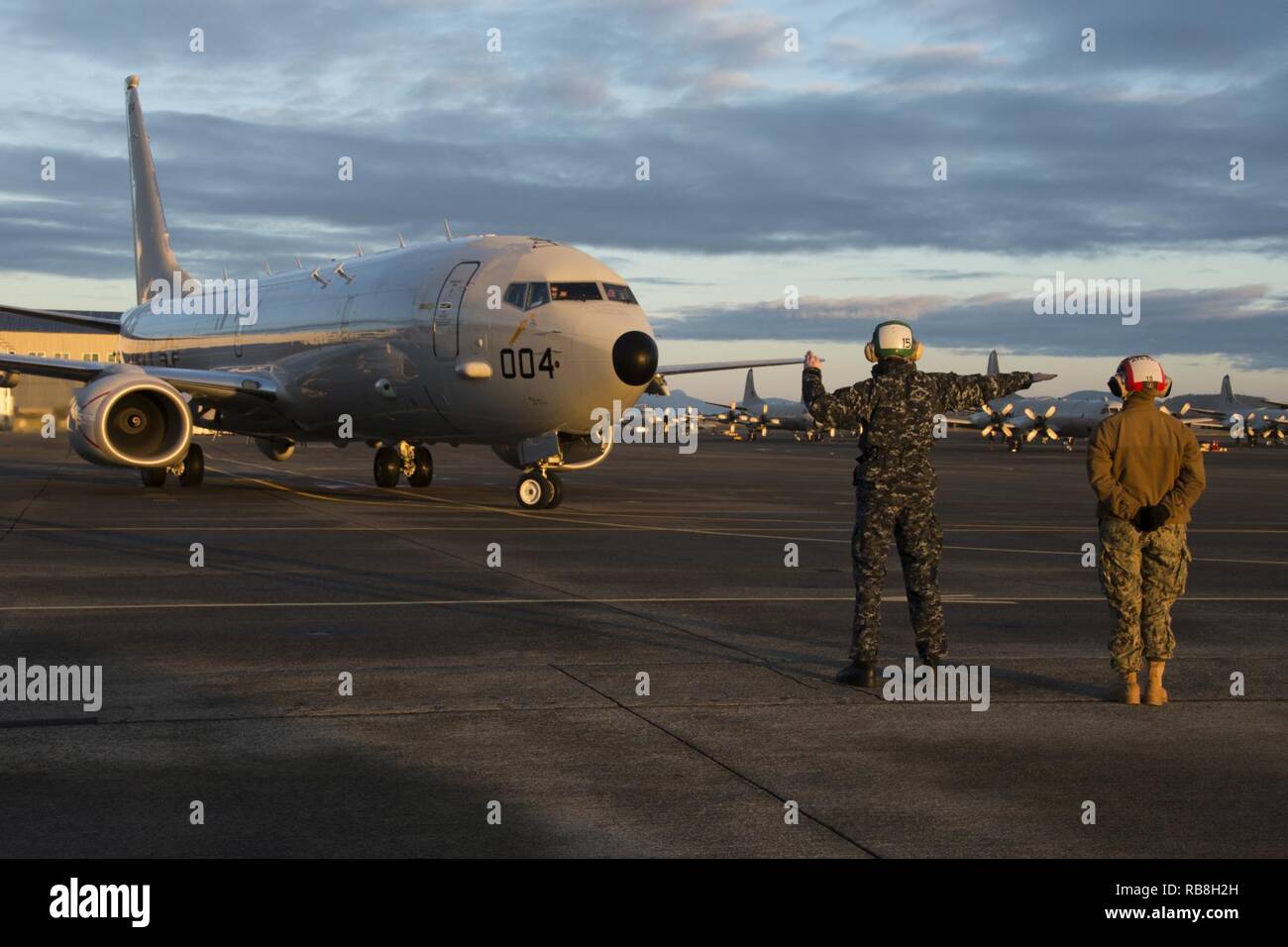 OAK HARBOR, Wash. (Dec. 13, 2016) Petty Officer 2nd Class Robert Ballew, left, of Patrol Squadron (VP) 4’s Skinny Dragons and Mallory Burton of Patrol Squadron (VP) 30.1’s Pros Nest taxi and direct VP-4’s first P-8 Poseidon flight  on Naval Air Station (NAS) Whidbey Island’s Ault Field. VP-4 is currently in transition from the P-3 Orion, in naval service since the 1960’s, to the P-8 Poseidon aircraft and will be the first P-8 squadron stationed at NAS Whidbey Island. Stock Photo