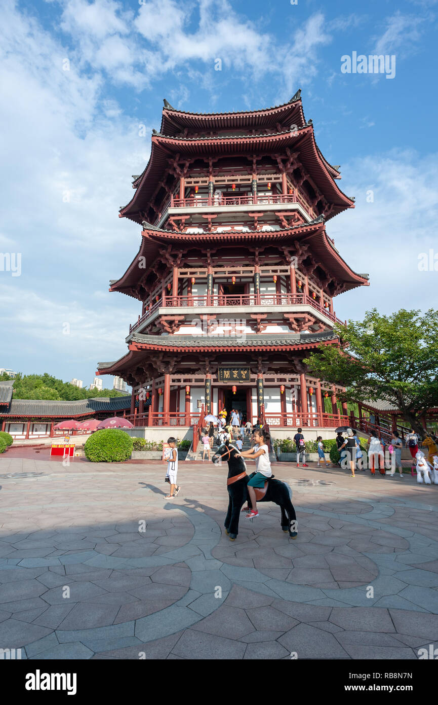Xi'an, Shaanxi province, China - Aug 12, 2018 : Chinese girl playing in front of a pagoda in Tang paradise park Stock Photo