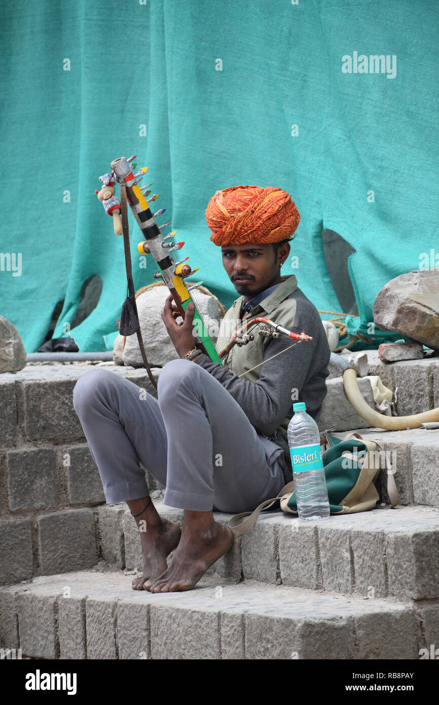 KANGRA DISTRICT, HIMACHAL PRADESH, INDIA, May 2017, Man on the streets playing music on musical intrument at McLeod Ganj Stock Photo