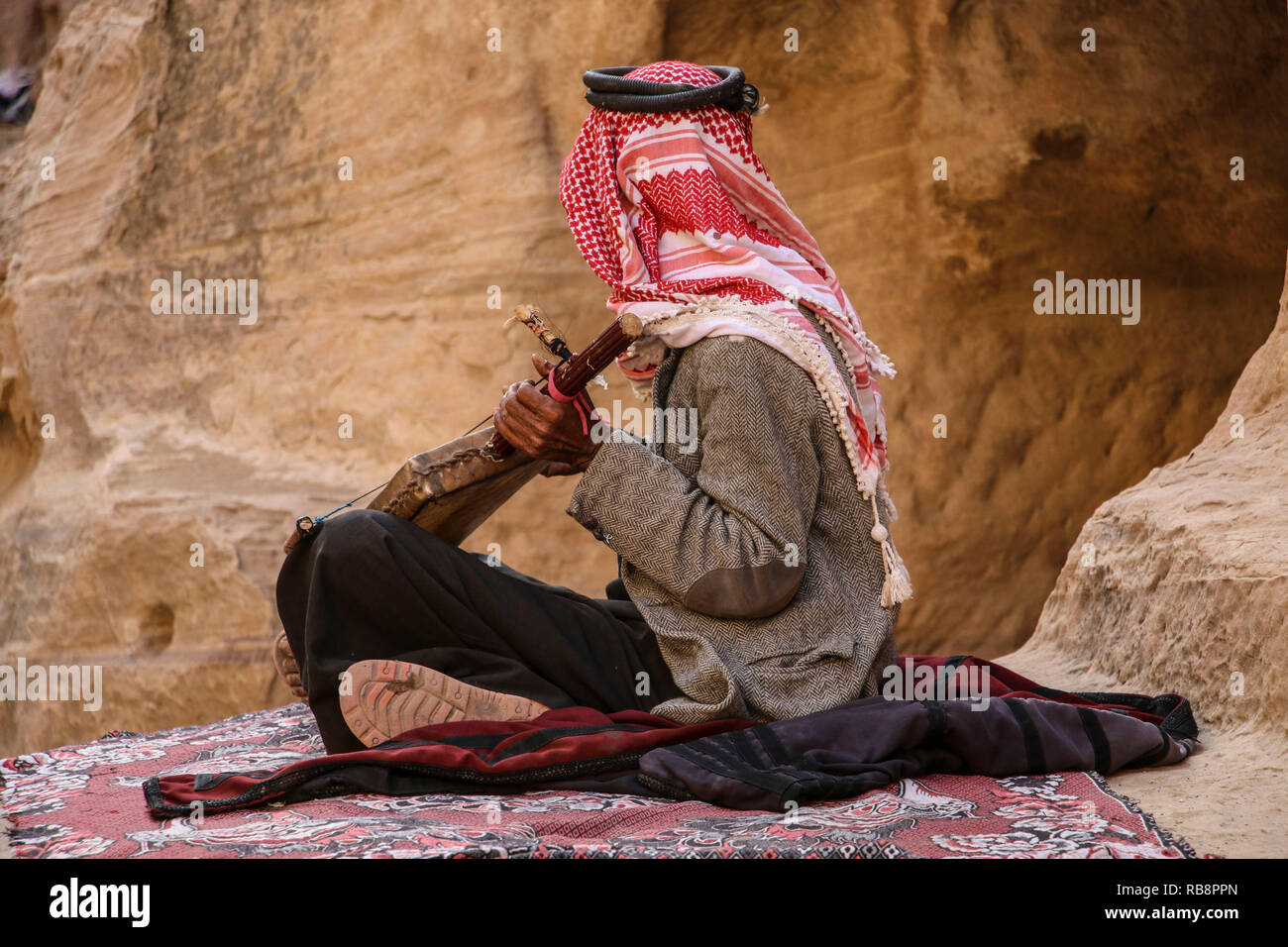 Old bedouin in the keffiyeh plays on the national musical instrument of ...