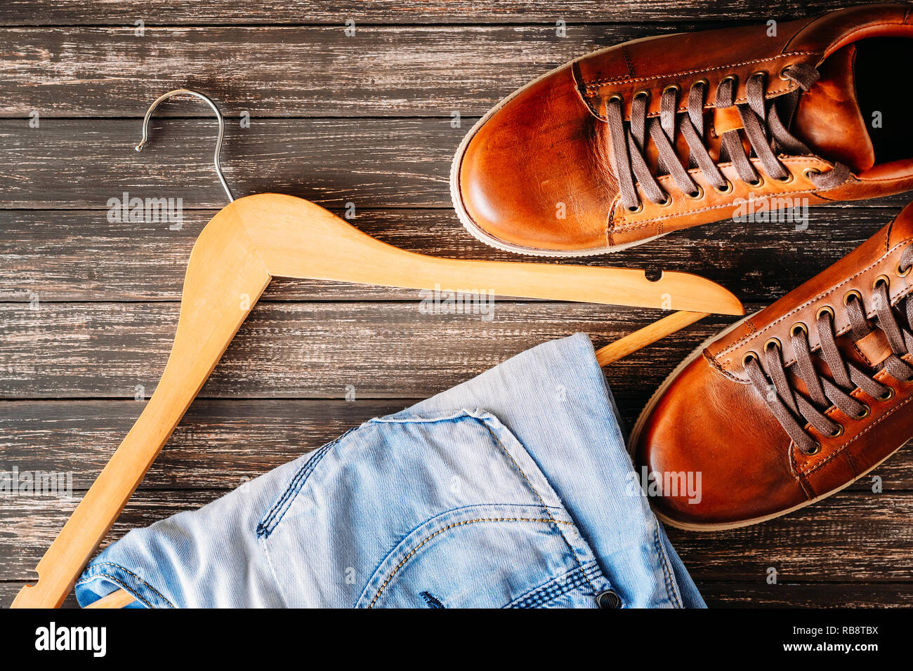 Man fashion concept. Male casual leather brown shoes, jeans and hanger on dark background Stock Photo - Alamy Man fashion concept. Male casual leather brown shoes, jeans and hanger on dark background Stock Photo - Alamy