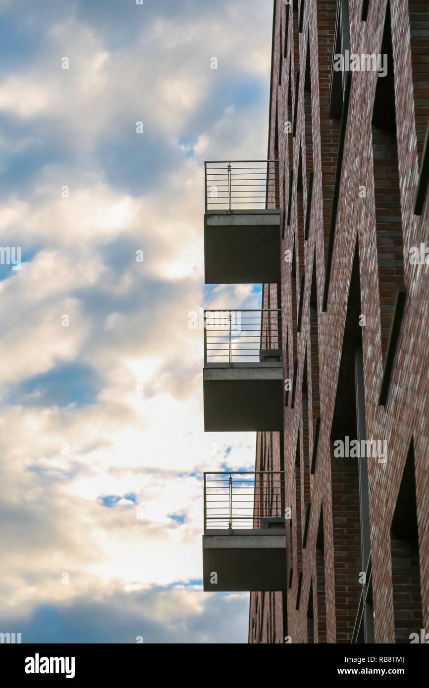 New facade with angular balconies and brick wall Stock Photo - Alamy