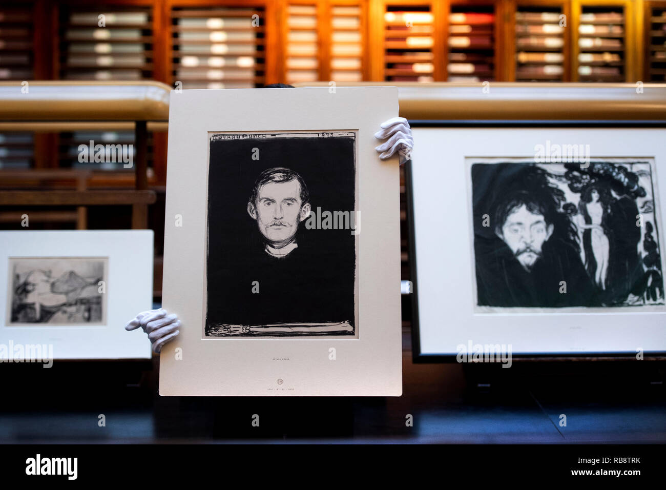 A staff member at the British Museum in London holds 'Self-Portrait' (1895) by Edvard Munch ahead of a major exhibition on the artist's work, 'Edvard Munch: love and angst', later in the year. Stock Photo