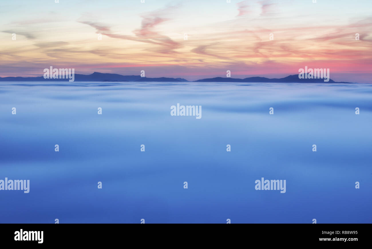 Dramatic clouds with mountain silhouette in dawn, Slovakia. Stock Photo