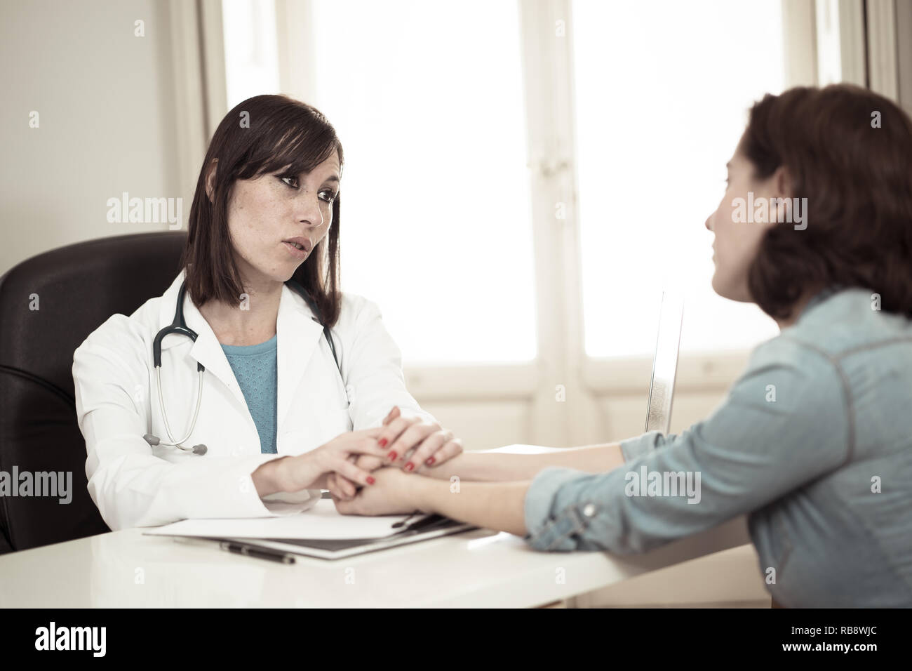 Female doctor discussing diagnosis with woman patient reassuring and comforting her with empathy in hospital office for Partnership Trust, Medical eth Stock Photo