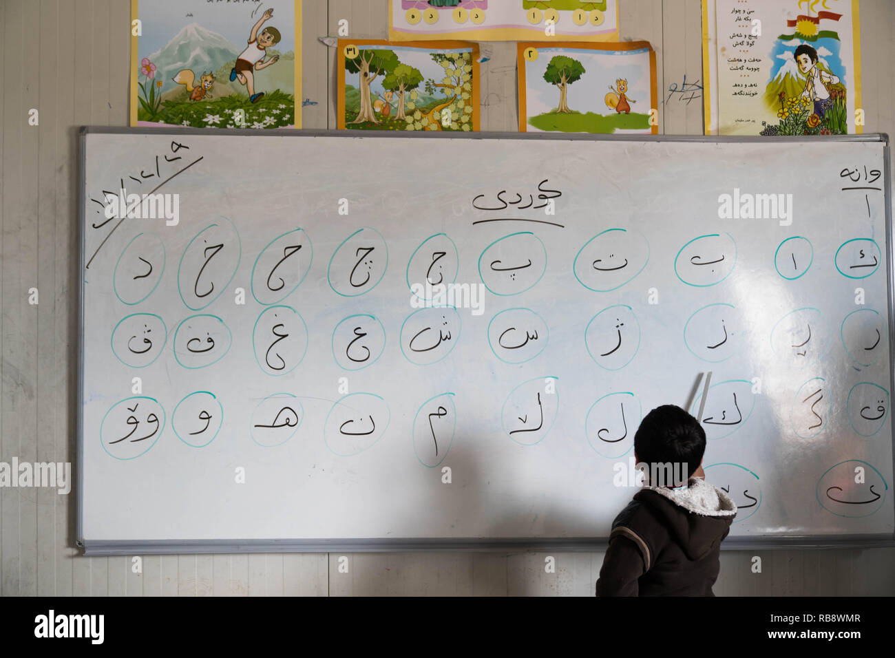 A Yazidi child seen learning the Kurdish letters at the school in the Bajed Kandala Camp. The Bajed Kandala IDP camp is hosting over 9000 Yazidi Internally Displaced Persons from Sinjar where they lost their homes to the ISIS militants in August 2014. Stock Photo