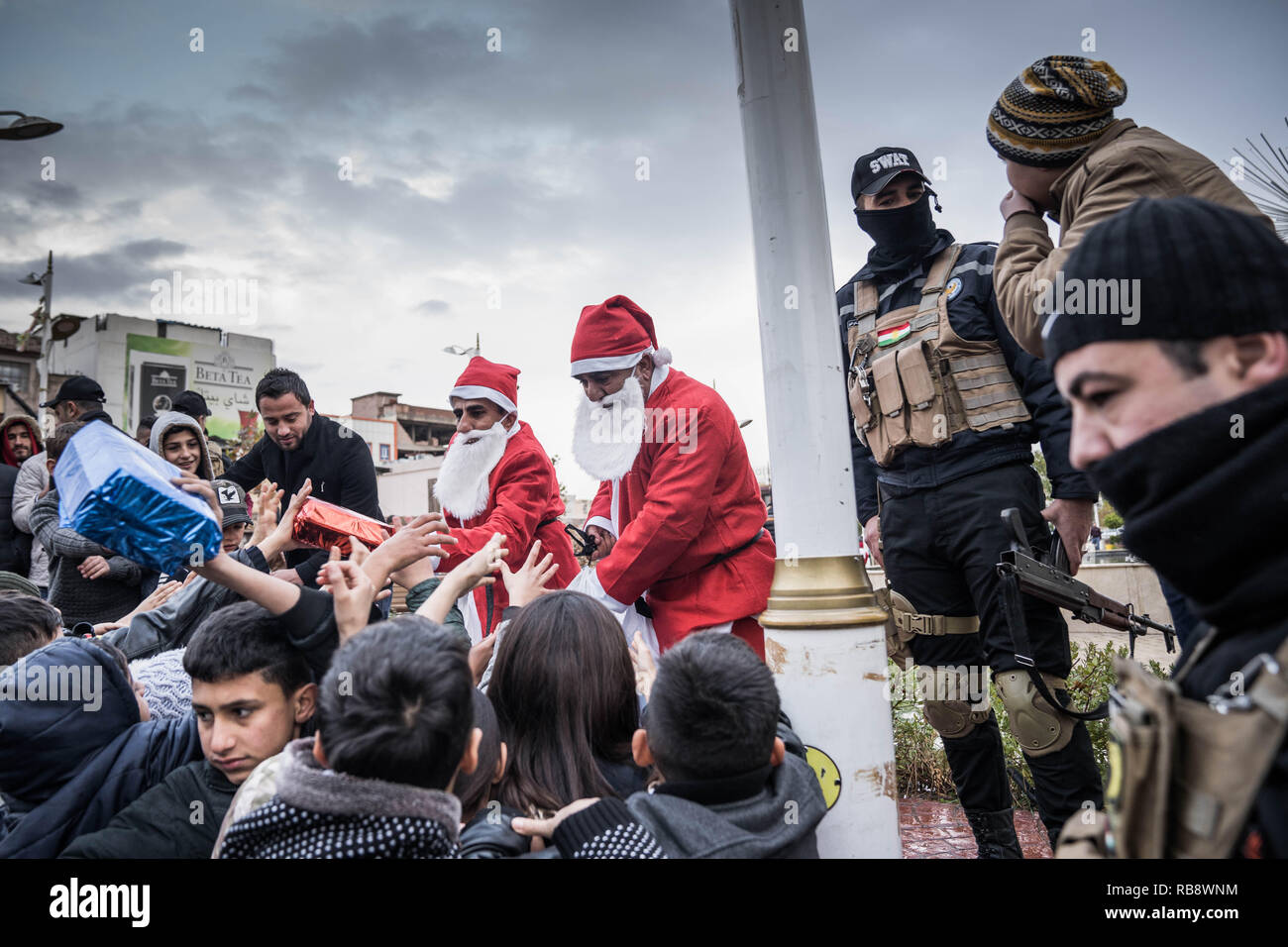 Armed military police deployed to keep order when Santa give out present to the local children in the town of Zakho in Kurdistan Iraq. Stock Photo