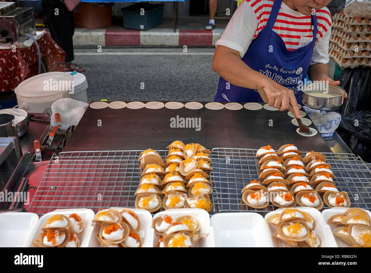 Thailand sweet. Food vendor preparing a popular Thailand sweet known as Khanom Bueang at her street food stall. Stock Photo