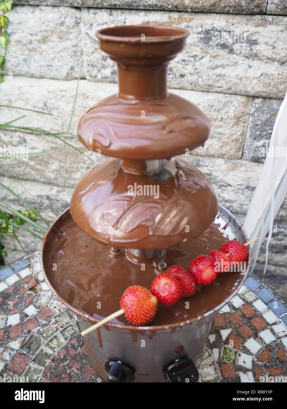 Dark chocolate fountain with strawberry stick Stock Photo Alamy