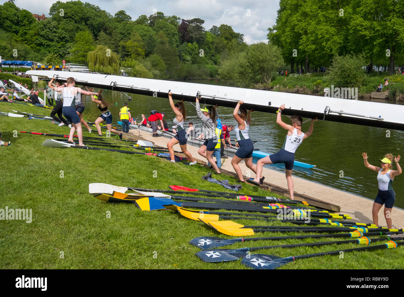 A rowing crew lifting a boat out of the River Severn at Shrewsbury