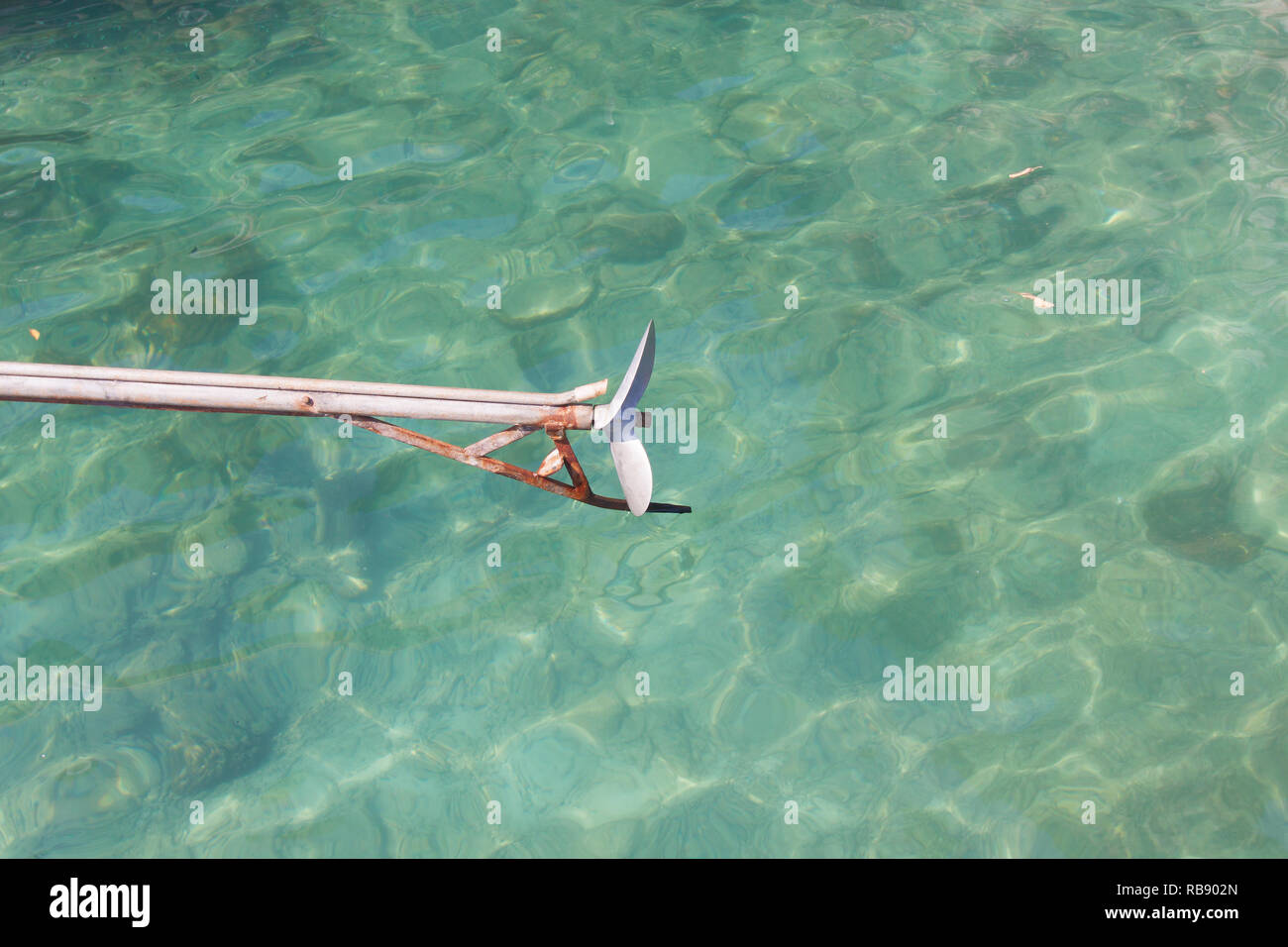 Long tail boat propeller in emerald sea. Stock Photo