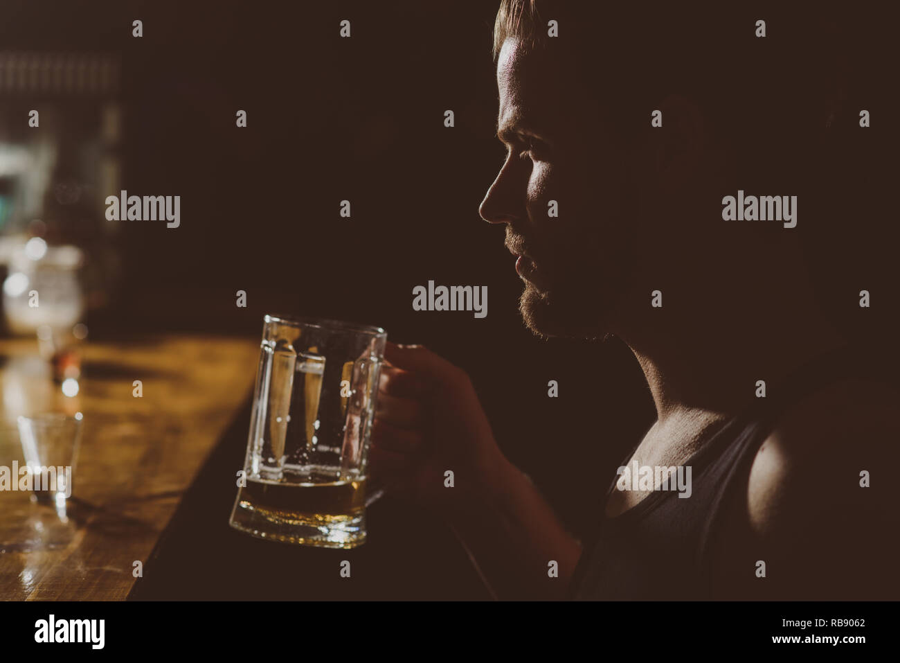 A cold beer after work. Handsome man drink beer at bar counter. Man