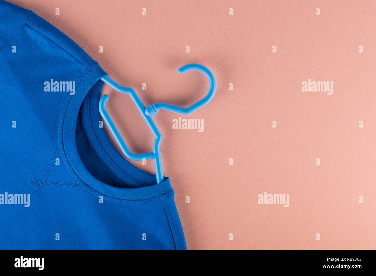 Blue long sleeve t-shirt on a plastic hanger. Store concept Stock Photo
