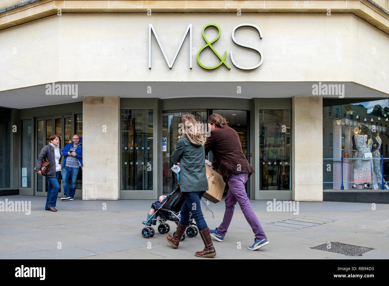High street shoppers are pictured walking past a Marks & Spencer