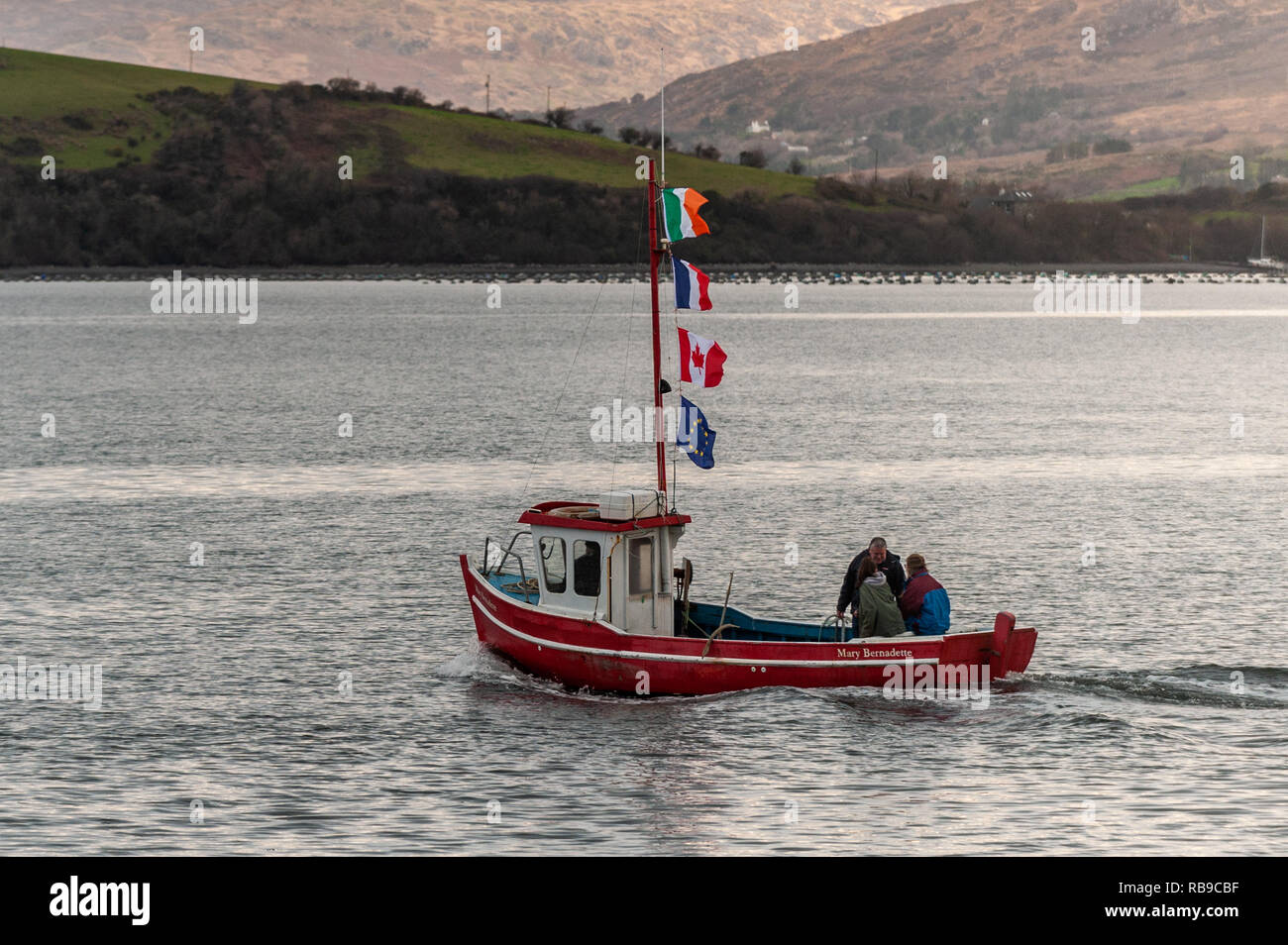 Bantry, West Cork, Ireland. 8th Jan, 2019. On the 40th Anniversary of the Whiddy Island disaster, in which the French oil tanker Betelgeuse exploded killing 50, a huge crowd attended the formalities in Abbey Graveyard, Bantry. A boat flying the Irish, French, Canadian and EU flags, sails to Whiddy with relatives of the dead on-board.  Credit: AG News/Alamy Live News. Stock Photo