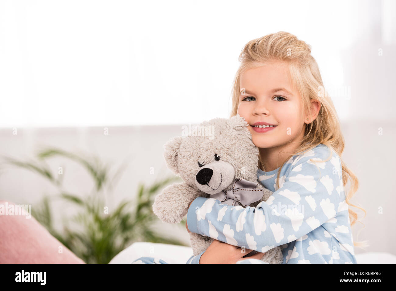 adorable child hugging teddy bear in bedroom Stock Photo - Alamy