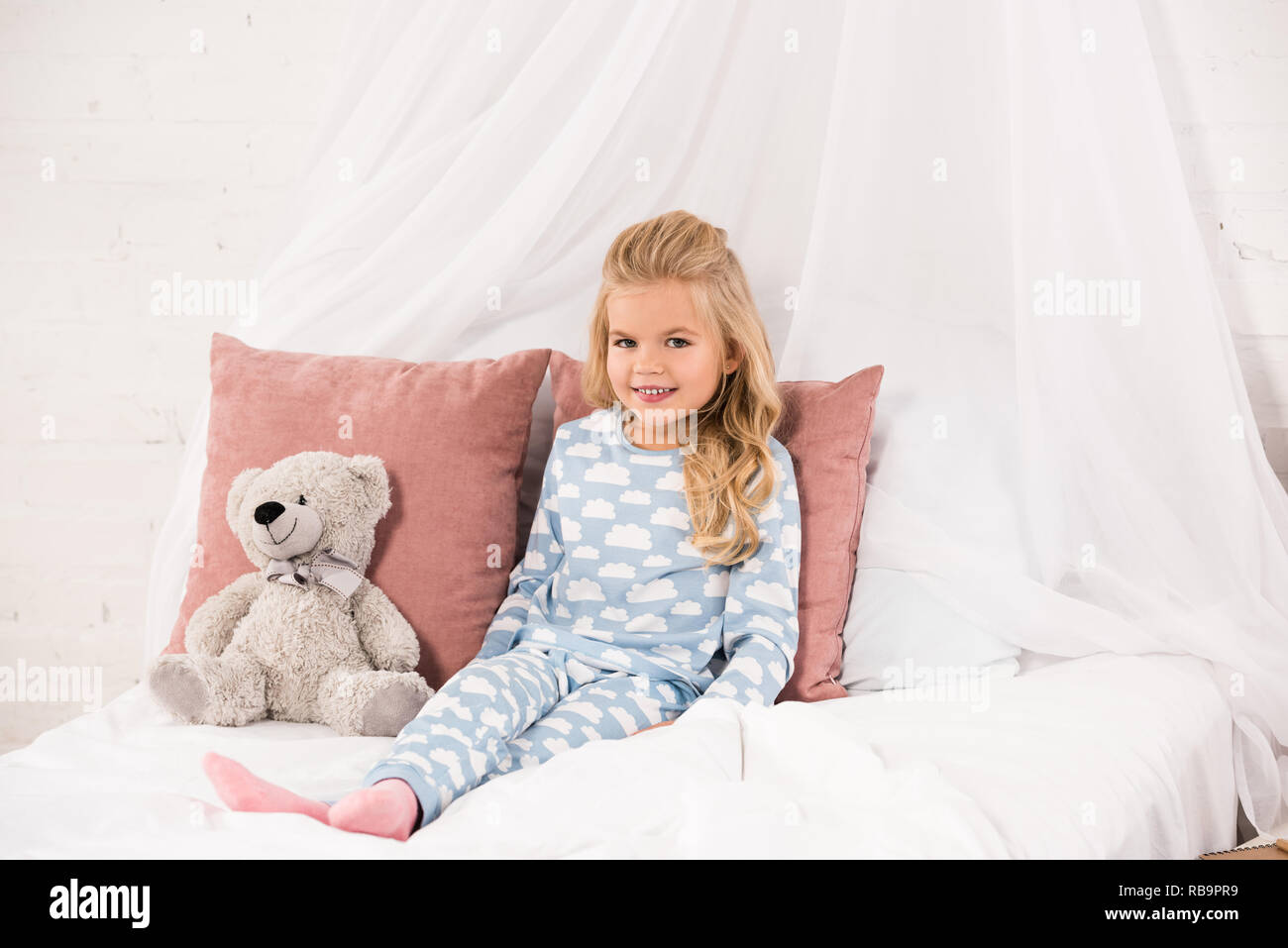 adorable child sitting on bed with teddy bear Stock Photo - Alamy