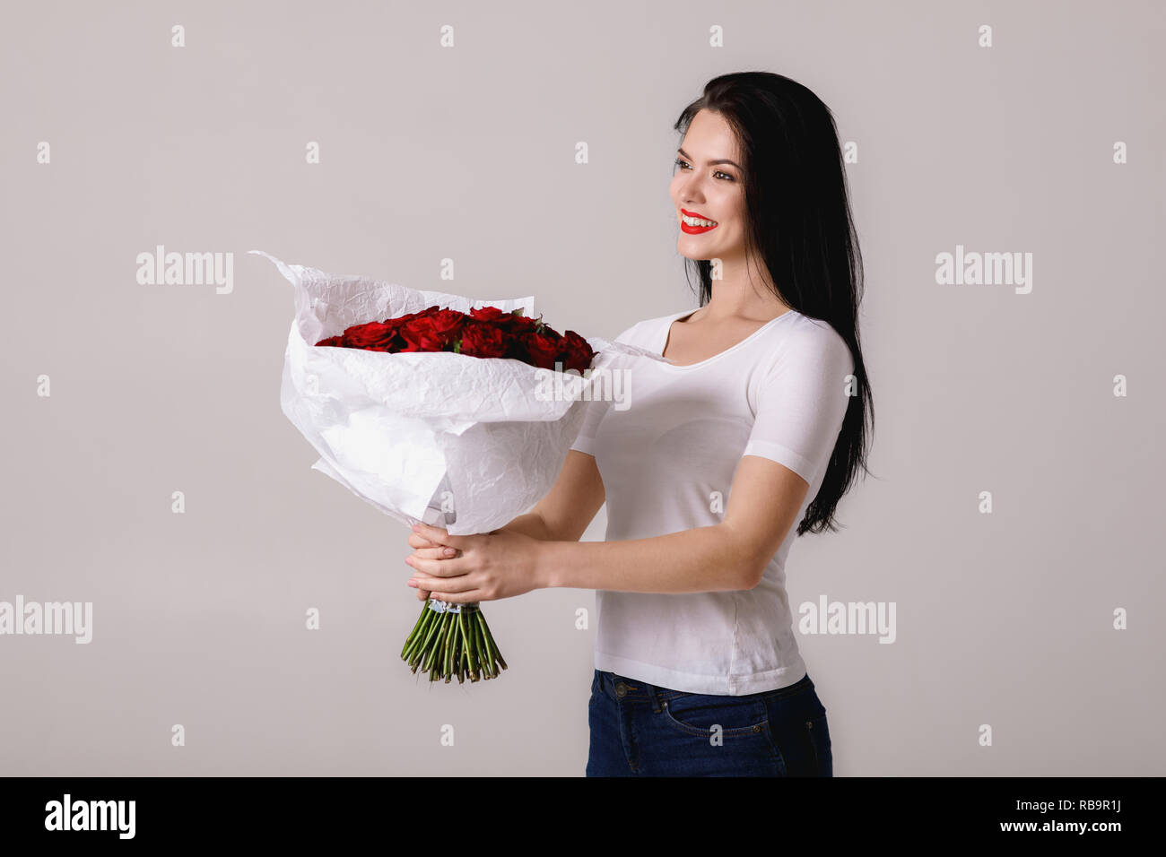 beautiful young woman with a large bouquet of red roses Stock Photo - Alamy