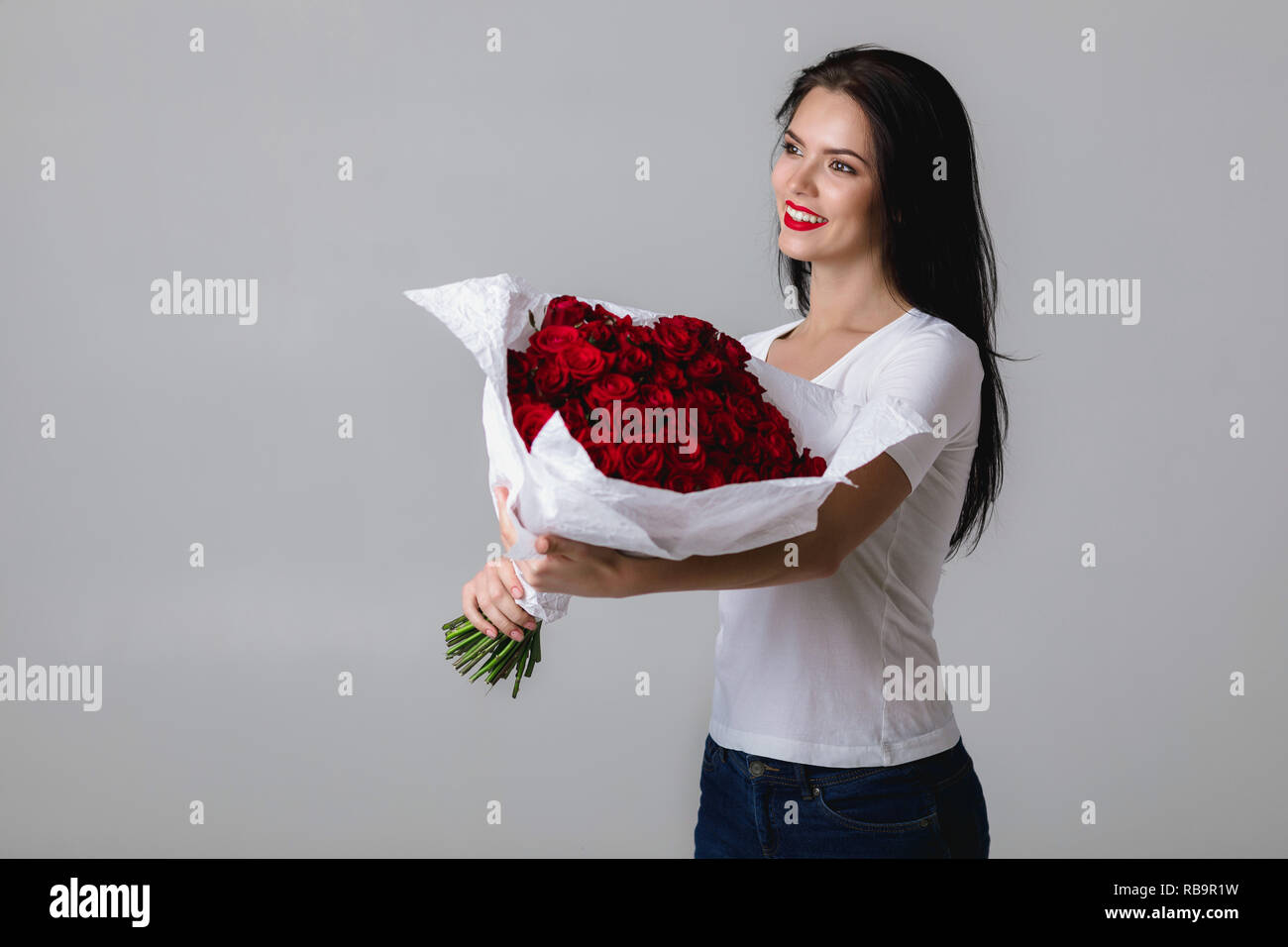 beautiful young woman with a large bouquet of red roses Stock Photo - Alamy