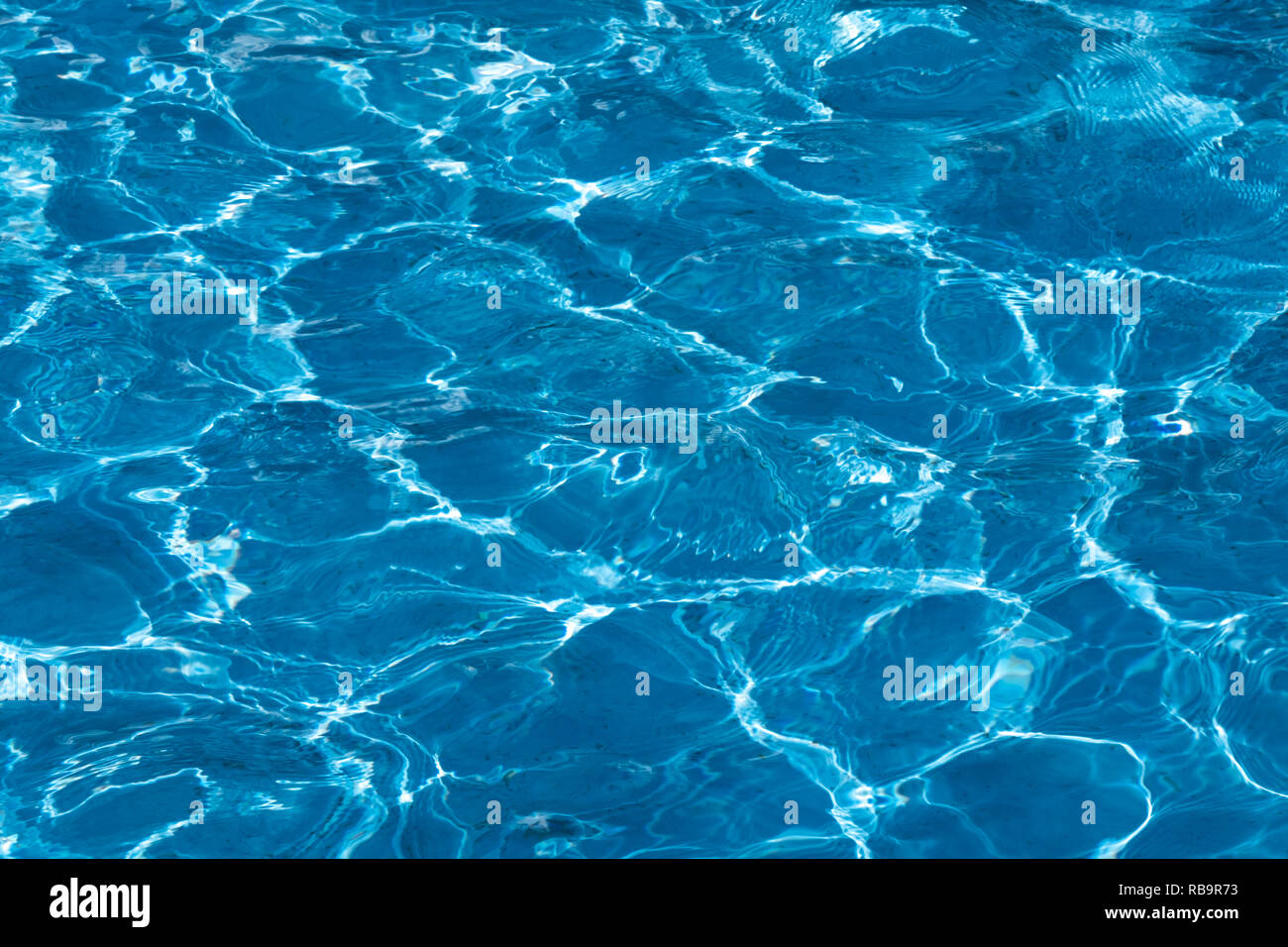 Blue and bright ripple clean water surface in swimming pool with sun ...