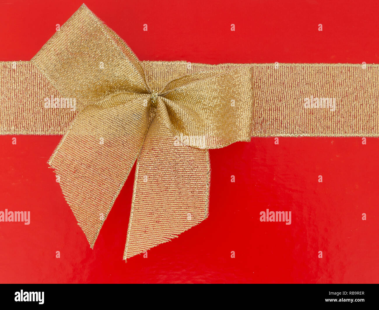 Red background with gold ribbon bow. Ideal Valentine etc. Stock Photo