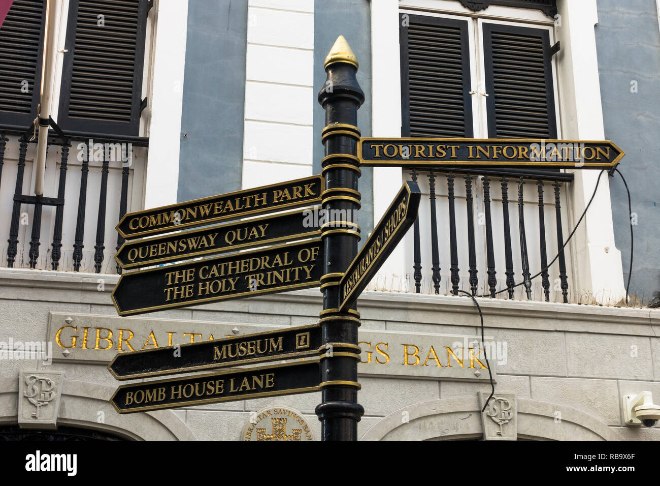 British style direction signpost, pedestrians in Main Street. Gibraltar, overseas territory, Europe. Stock Photo