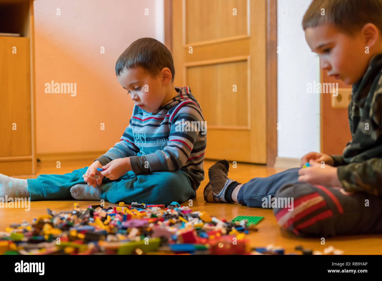 Two children playing with lots of colorful plastic blocks constructor ...