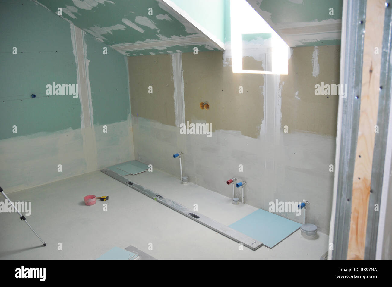 Attic bathroom with skylight under construction with drywall taping. Stock Photo