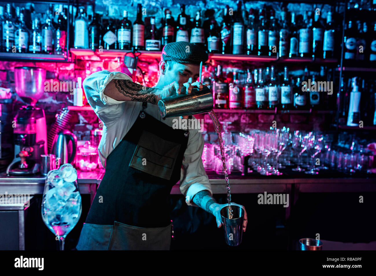 Expert barman is making cocktail with shaker at night club. Copy space  Stock Photo - Alamy