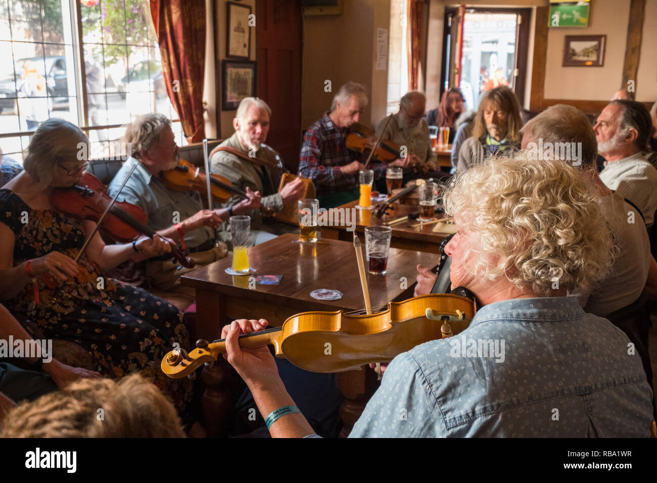 Musicians playing violins in the Wheatsheaf pub during Shrewsbury Folk Festival, Shropshire, England, UK Stock Photo
