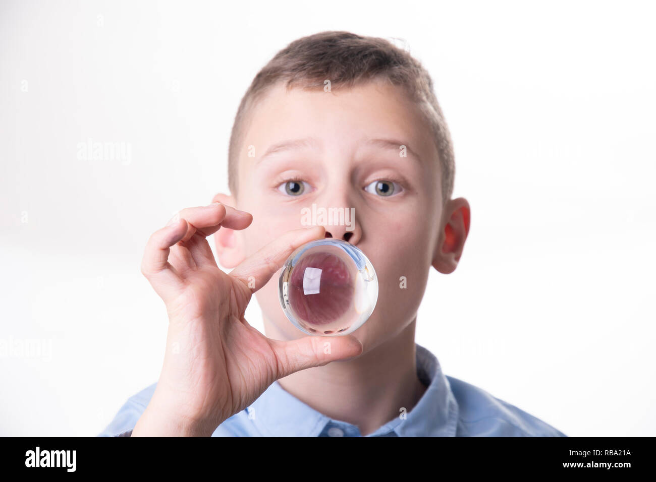 Future - boy breathes into a glass ball directly in front of his mouth isolated on white background Stock Photo