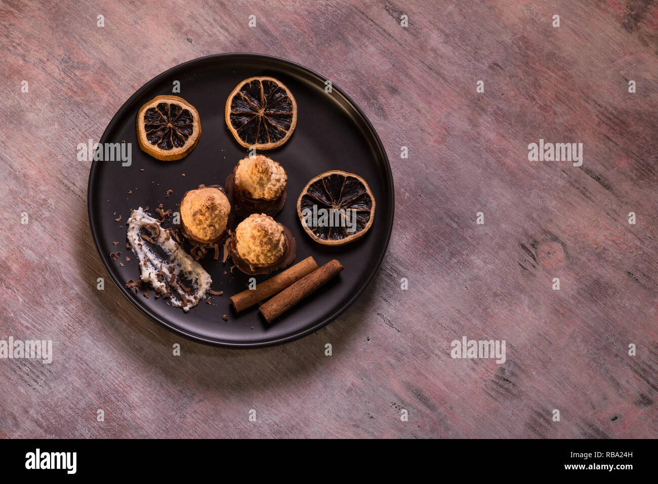 Horizontal photo of few pieces of baked homemade sweets. Confection has nice crust and chocolate on bottom. Few pieces of dry orange rings are around  Stock Photo
