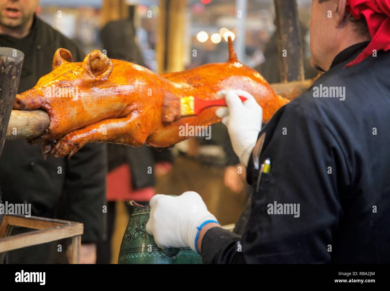 chef marinating a spit roast pig Stock Photo