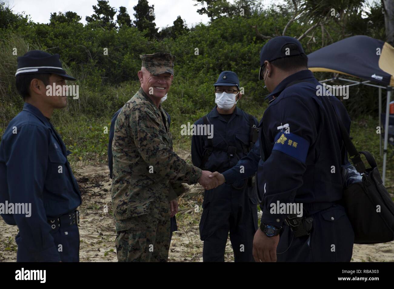 NAGO CITY, OKINAWA, Japan – Lt. Gen. Lawrence Nicholson, the Okinawa Area Coordinator and the III Marine Expeditionary Force commanding general, meets with Okinawa Prefectural Police Officers working with Marines to recover a downed MV-22 Osprey Dec. 19 near Abu, Nago City, Okinawa, Japan. While visiting the site, Nicholson also met with local officials and residents.  Nicholson was very thankful for the Japan Coast Guard, Okinawa Prefectural Police, and other Japanese agencies for their critical assistance in the recovery of the crew. Stock Photo