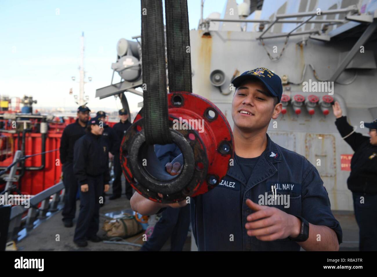 - VALENCIA, Spain (Dec. 20, 2016) Petty Officer 3rd Class Enrique Gonzalez, from San Bernardino, Calif., hoists a fuel line adapter aboard the guided-missile destroyer USS Porter (DDG 78) as the ship prepares to take on fuel pier-side in Valencia, Spain, Dec. 20, 2016. Porter, forward-deployed to Rota, Spain, is conducting naval operations in the U.S. 6th Fleet area of operations in support of U.S. national security interests in Europe. Stock Photo