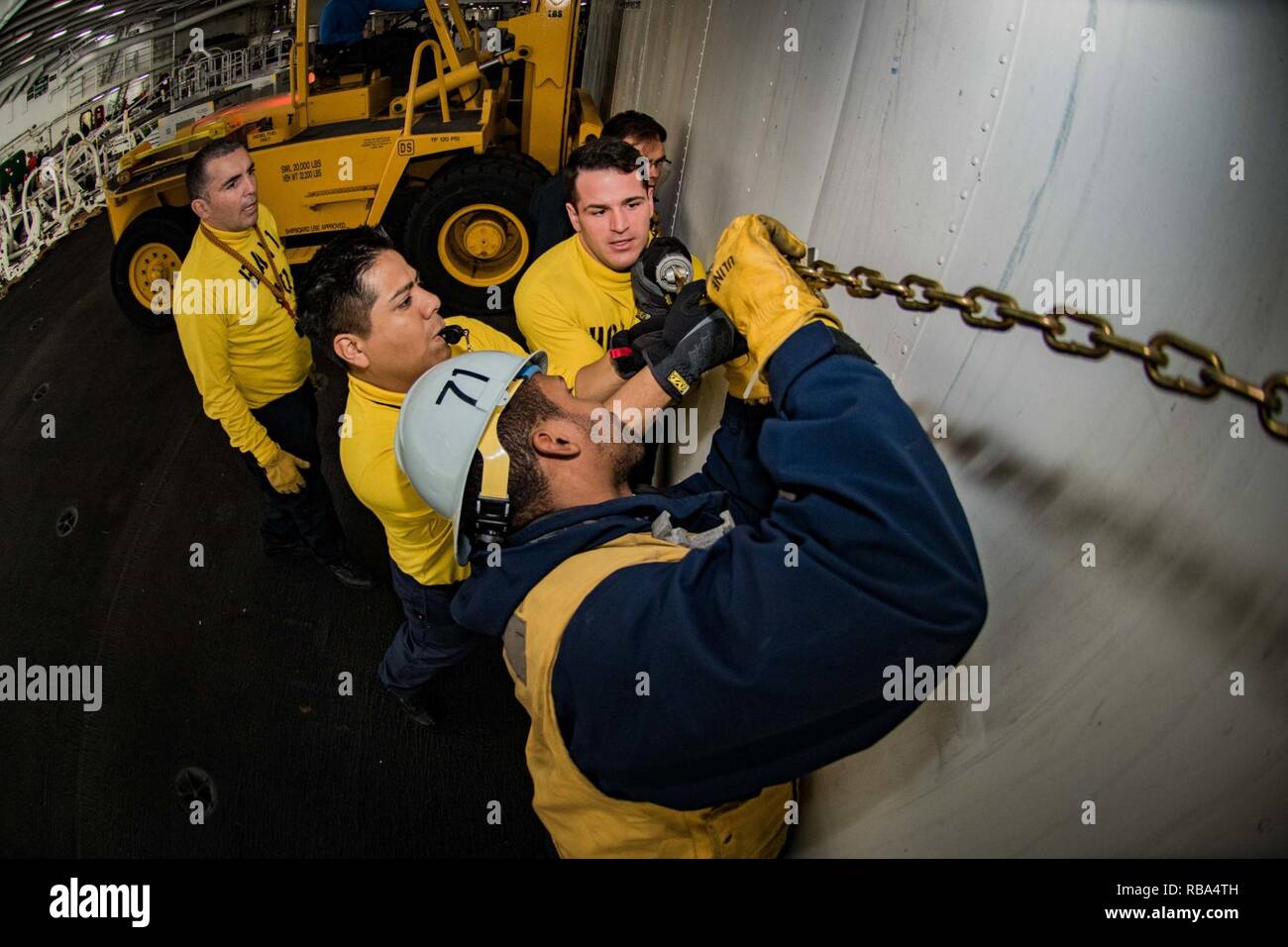 SAN DIEGO (Dec. 21 2016) Sailors secure a conex box to a forklift in the hangar bay of the aircraft carrier USS Theodore Roosevelt (CVN 71). Theodore Roosevelt is currently conducting exercises in the U.S. 3rd Fleet area of operations at the conclusion of its six month Planned Incremental Availability. Stock Photo