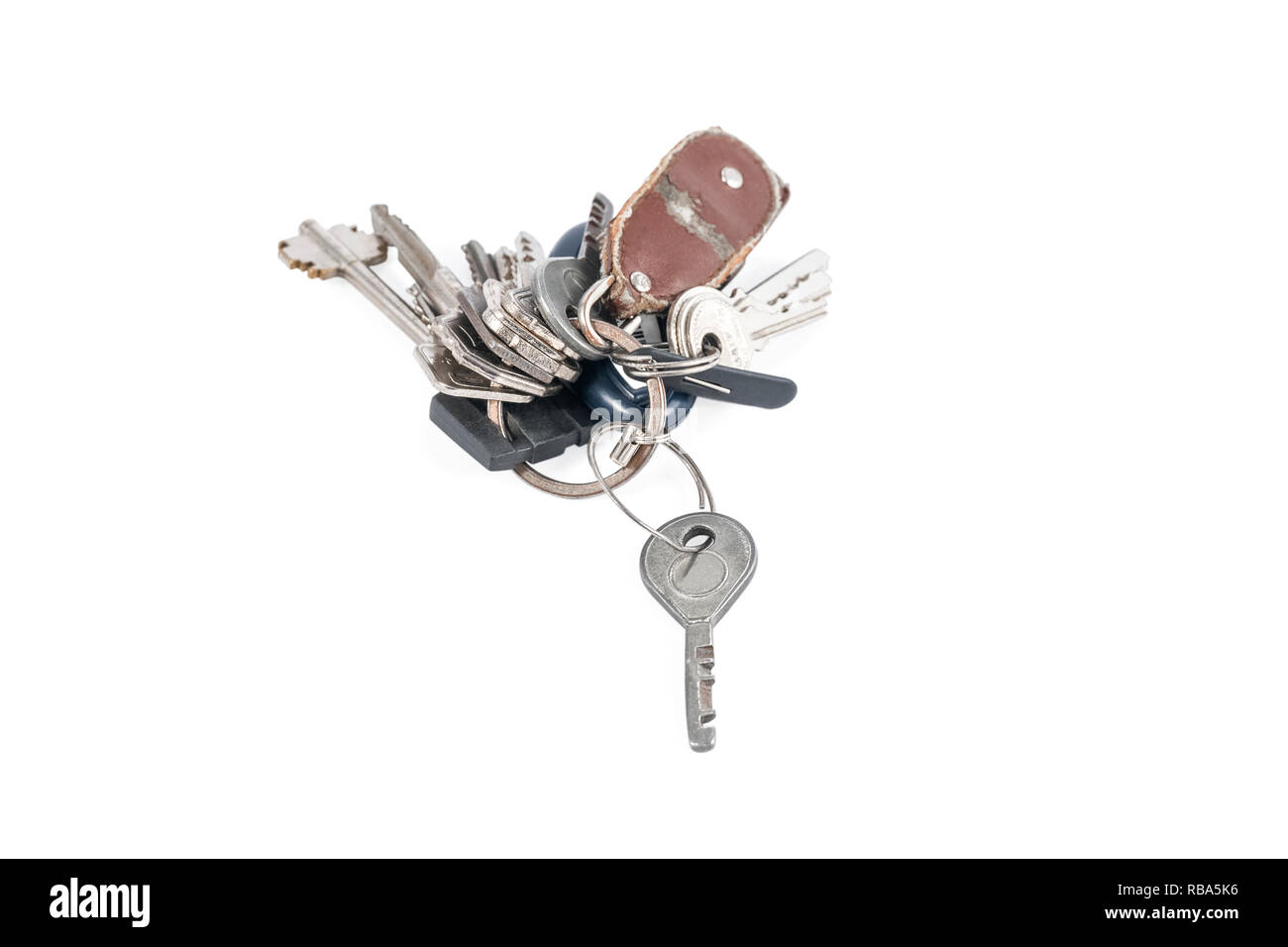 Many old keys on a ring with a torn keychain isolated on white background Stock Photo