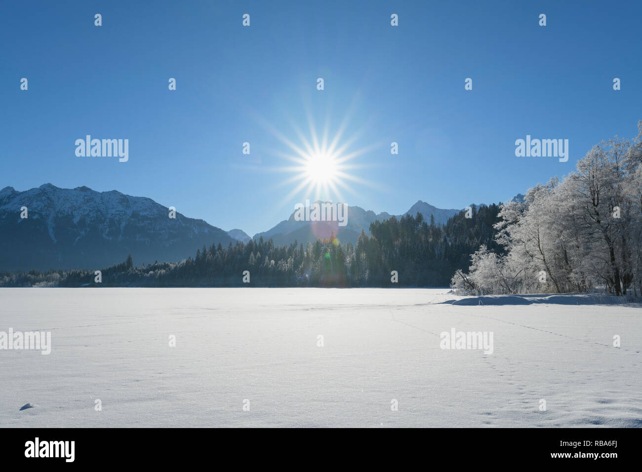Frozen lake Barmsee with Karwendel mountainrange on morning with sun in ...