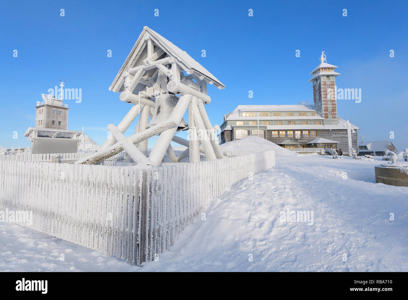 Peace bell, weather station and Fichtelberghaus, on the summit of Fichtelberg with snow in winter, Mount Fichtelberg, Oberwiesenthal, Erzgebirge, Ore  Stock Photo